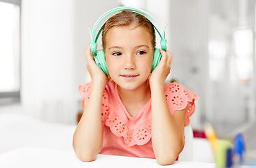 Image showing girl in headphones listening to music at home