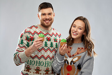 Image showing couple with cupcakes in ugly christmas sweaters