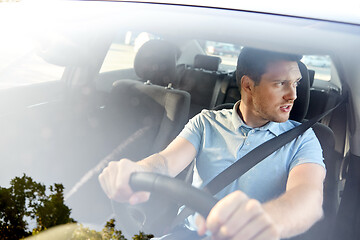 Image showing displeased young man or driver driving car