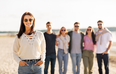 Image showing happy woman with friends on beach in summer