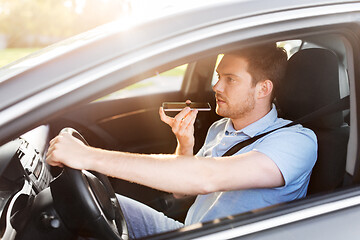 Image showing man driving car and recording voice by smartphone