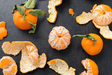 Image showing close up of peeled mandarins on slate table top