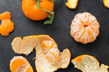 Image showing close up of peeled mandarins on slate table top