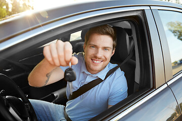 Image showing smiling man or driver with key sitting in car