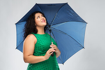 Image showing happy woman in green dress with blue umbrella