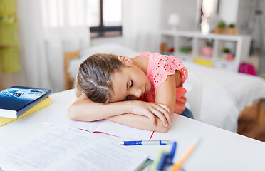 Image showing tired student girl sleeping on table at home