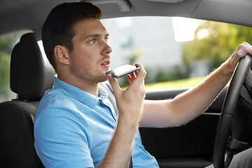 Image showing man driving car and recording voice by smartphone