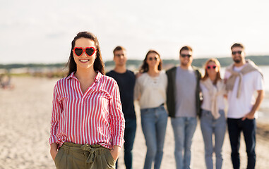 Image showing happy woman with friends on beach in summer