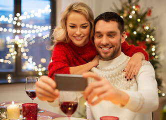 Image showing happy couple taking selfie at christmas dinner