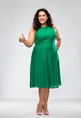 Image showing happy woman in green dress showing thumbs up