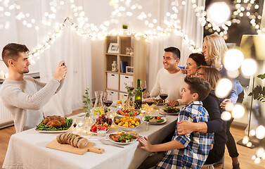 Image showing family having dinner party and taking selfie