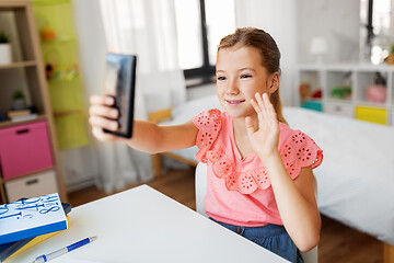 Image showing happy girl with smartphone taking selfie at home