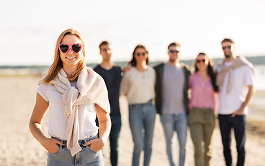 Image showing happy woman with friends on beach in summer