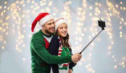 Image showing happy couple in christmas sweaters taking selfie