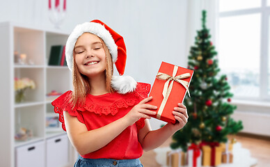 Image showing girl in santa hat with christmas gift at home