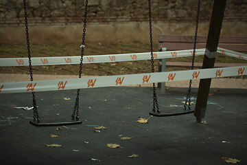 Image showing Set of two swings cordoned off on a playground