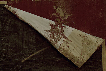 Image showing Edge of a peeling poster on a red wall