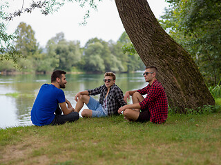 Image showing men sitting on the bank of the river