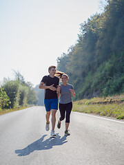 Image showing young couple jogging along a country road