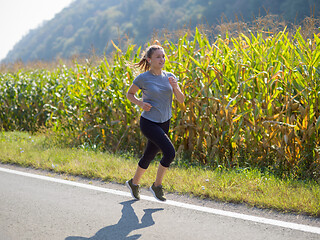 Image showing woman jogging along a country road