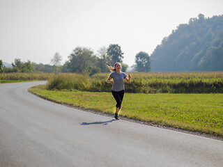 Image showing woman jogging along a country road