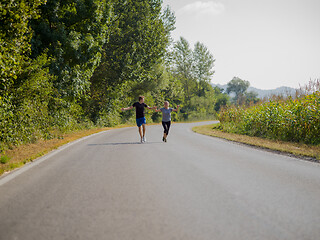 Image showing young couple jogging along a country road