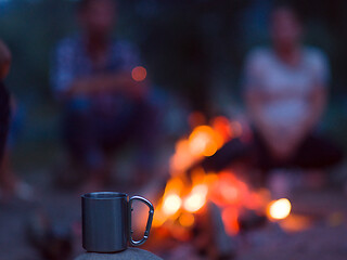 Image showing young friends relaxing around campfire