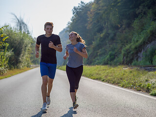 Image showing young couple jogging along a country road