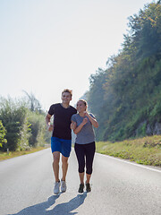 Image showing young couple jogging along a country road