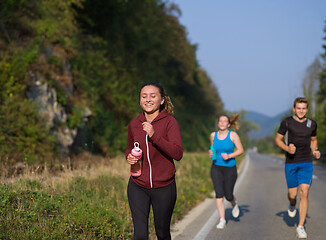 Image showing young people jogging on country road