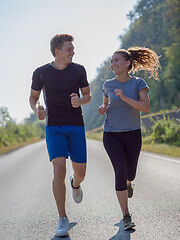 Image showing young couple jogging along a country road