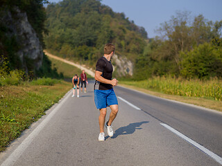 Image showing young people jogging on country road