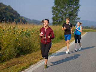 Image showing young people jogging on country road