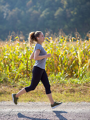 Image showing woman jogging along a country road