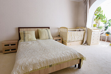 Image showing Bedroom interior, adult bed, newborn crib and changing table nearby