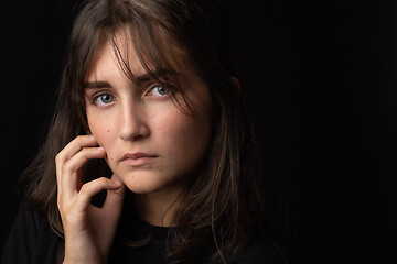 Image showing Portrait of a beautiful girl with a thoughtful look on a black background