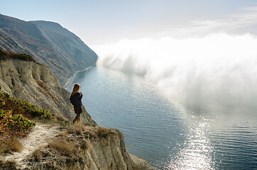 Image showing Girl from the mountain watching the clouds above the sea