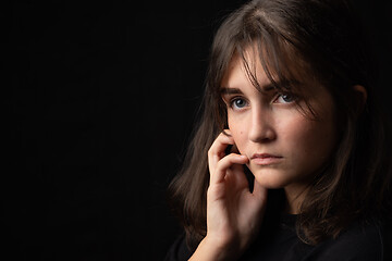 Image showing Psychological portrait of a beautiful young girl on a black background