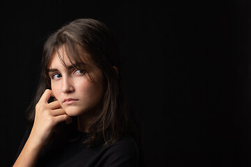 Image showing Art portrait of sixteen year old teenage girl in dark clothes on black background