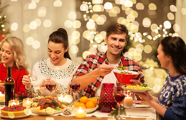 Image showing happy friends having christmas dinner at home