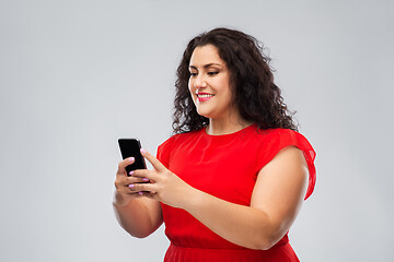 Image showing happy woman in red dress using smartphone