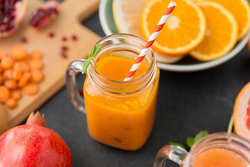 Image showing mason jar glass of carrot juice with paper straw