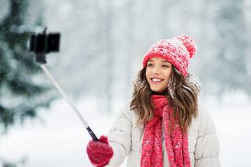 Image showing young woman taking selfie by monopod in winter