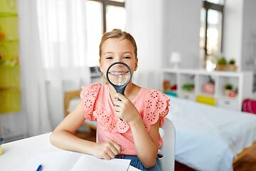 Image showing student girl with magnifier and notebook at home