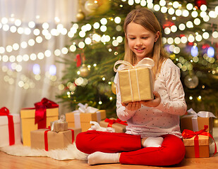 Image showing smiling girl with christmas gift at home