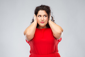 Image showing woman in red dress closing her ears by hands