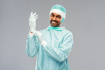 Image showing indian male doctor or surgeon putting glove on