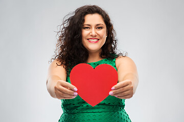 Image showing happy woman in green dress holding red heart