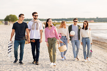 Image showing happy friends walking along summer beach