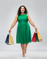 Image showing happy woman in green dress with shopping bags
